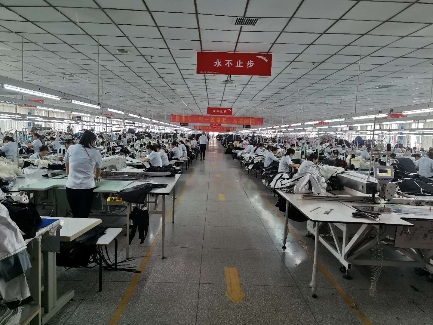 员工在缝制工位工作,展示制作现场而非检验现场